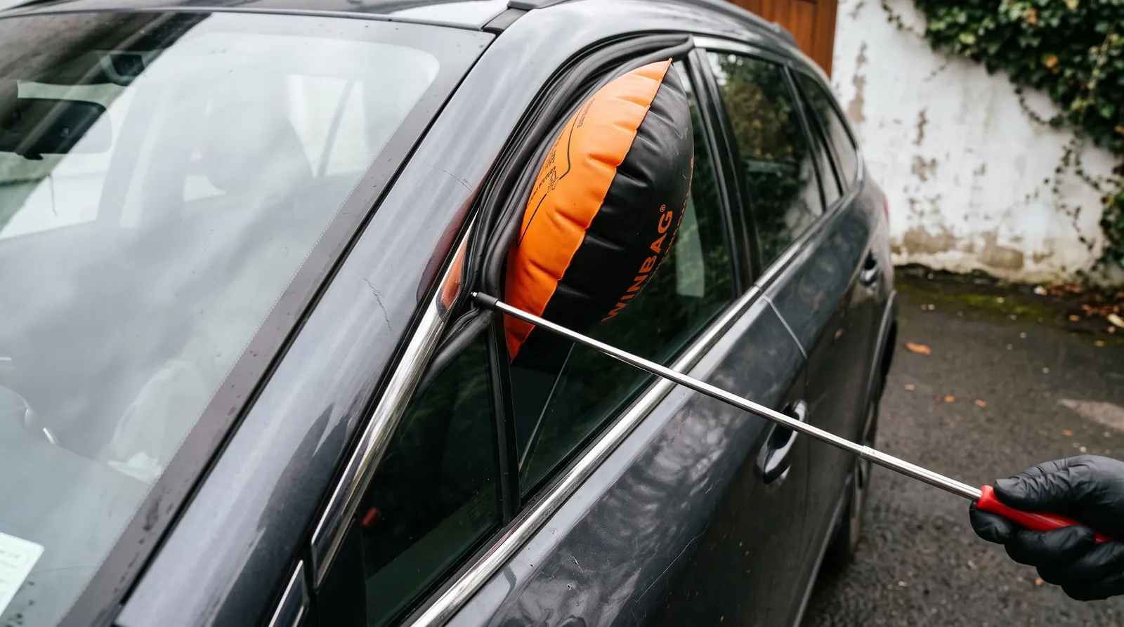Inflatable wedge in a car door frame with a long reach tool inserted